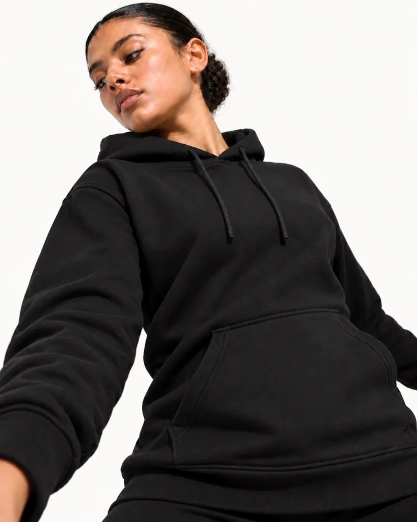 Adults Pullover Hoodie in black, shown on a dancer against an off-white studio background